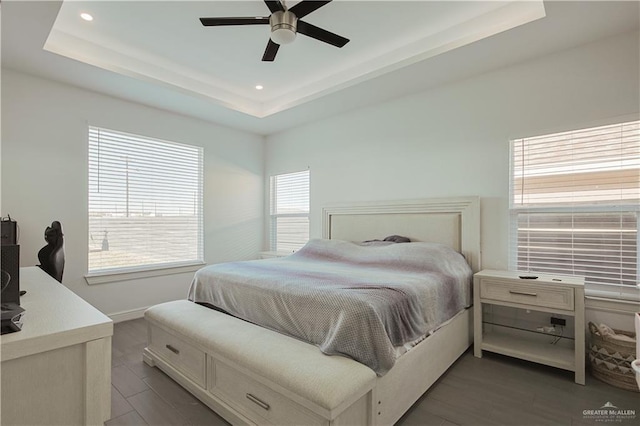 bedroom featuring recessed lighting, a ceiling fan, a tray ceiling, and wood finished floors