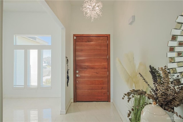 entrance foyer with baseboards and a notable chandelier