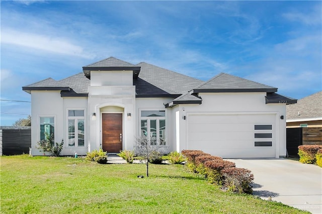 view of front of home with a front yard, roof with shingles, driveway, an attached garage, and stucco siding