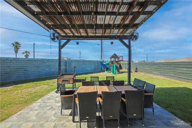 view of patio with playground community, a fenced backyard, and outdoor dining space