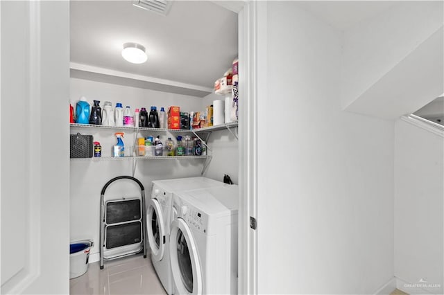 washroom with washing machine and dryer and light tile patterned flooring