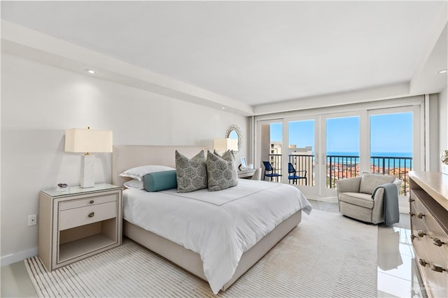 bedroom featuring a water view and access to outside