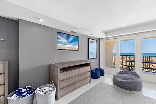 living area featuring tile patterned flooring and a water view