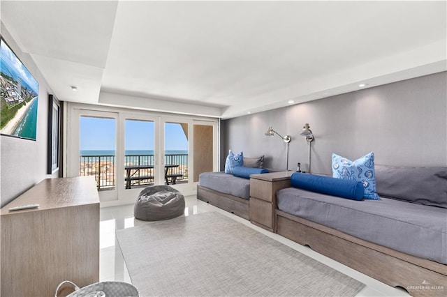 living room with a wealth of natural light, tile patterned flooring, and a water view