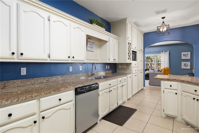 kitchen with arched walkways, light tile patterned floors, a sink, visible vents, and stainless steel dishwasher