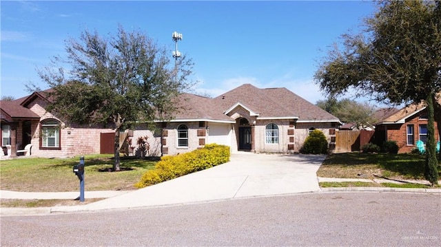 single story home featuring concrete driveway, an attached garage, fence, a front lawn, and brick siding