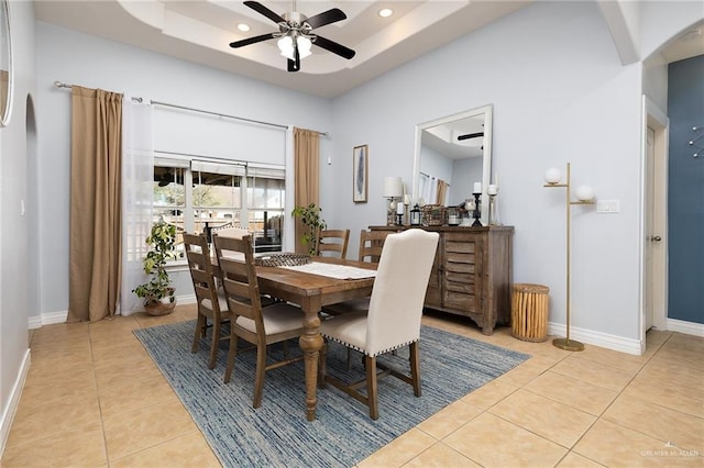 dining room with light tile patterned floors, recessed lighting, a raised ceiling, a ceiling fan, and baseboards