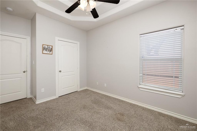 unfurnished bedroom featuring a ceiling fan, carpet, and baseboards