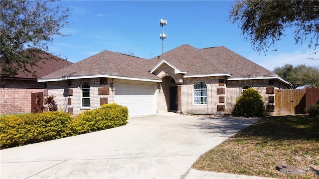 view of front of home featuring brick siding, roof with shingles, fence, a garage, and driveway