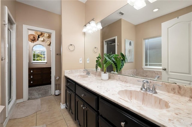 bathroom featuring tile patterned flooring, a sink, a shower stall, and double vanity