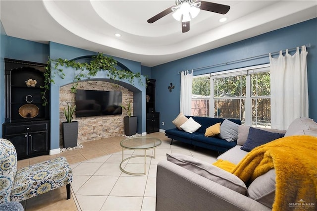 tiled living room featuring ceiling fan, baseboards, a raised ceiling, and recessed lighting