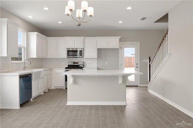 825 S Templo Dorado, Mission, TX 78572 - kitchen featuring appliances with stainless steel finishes, backsplash, white cabinets, a kitchen island, and recessed lighting
