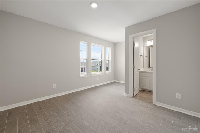 825 S Templo Dorado, Mission, TX 78572 - unfurnished bedroom with wood finished floors, baseboards, ensuite bath, and recessed lighting