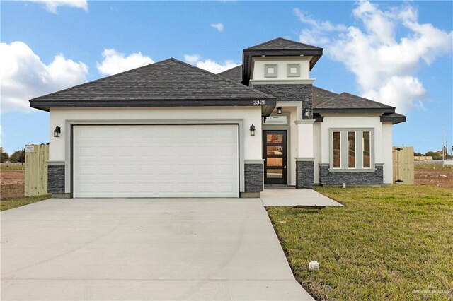 prairie-style home with a front yard and a garage