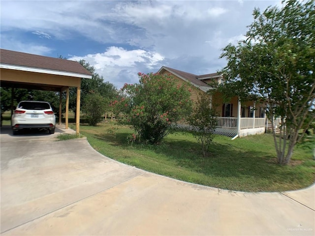 view of side of property featuring a porch, a yard, and a carport