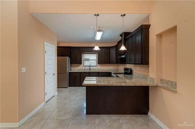 kitchen featuring dark brown cabinetry, sink, kitchen peninsula, pendant lighting, and appliances with stainless steel finishes