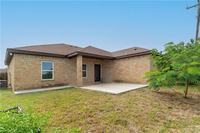 back of house with a patio area, a yard, and central AC