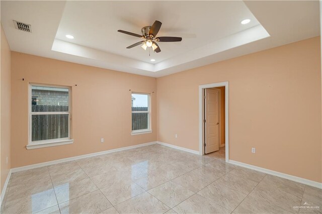 unfurnished room featuring ceiling fan and a tray ceiling