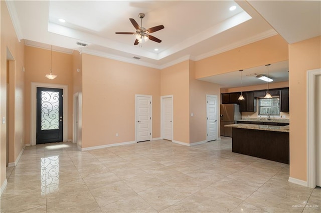 kitchen with a raised ceiling, light stone countertops, stainless steel fridge with ice dispenser, and dark brown cabinetry