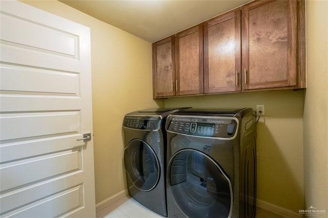 clothes washing area featuring washer and dryer and cabinets