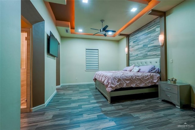 bedroom featuring a raised ceiling, ceiling fan, and dark hardwood / wood-style flooring