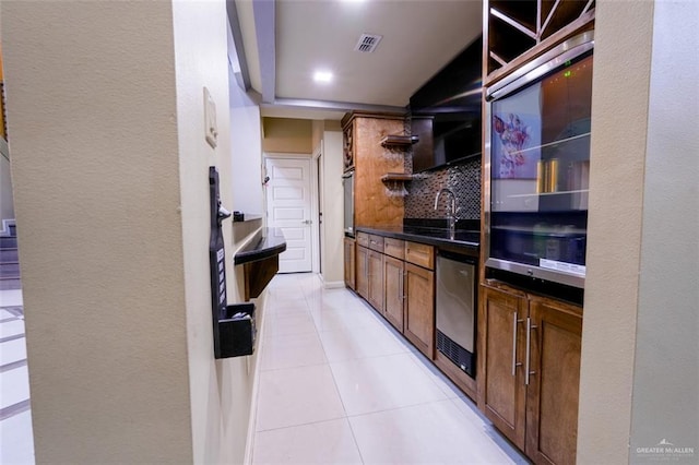 kitchen with backsplash, sink, light tile patterned floors, and stainless steel appliances