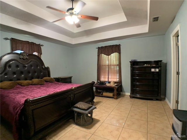 bedroom featuring a tray ceiling, ceiling fan, and light tile patterned flooring