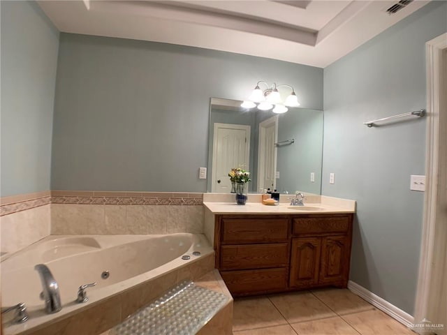 bathroom featuring tile patterned flooring, vanity, and tiled tub