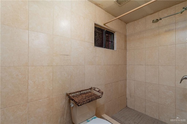 bathroom featuring tiled shower and toilet