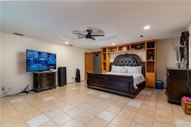 bedroom with ceiling fan, light tile patterned flooring, and a tray ceiling