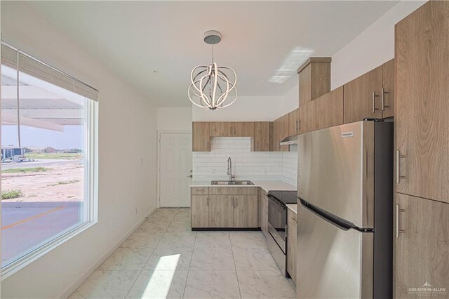 kitchen with sink, hanging light fixtures, stainless steel appliances, an inviting chandelier, and backsplash