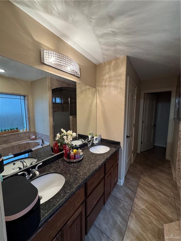 full bathroom with a garden tub, a sink, and double vanity