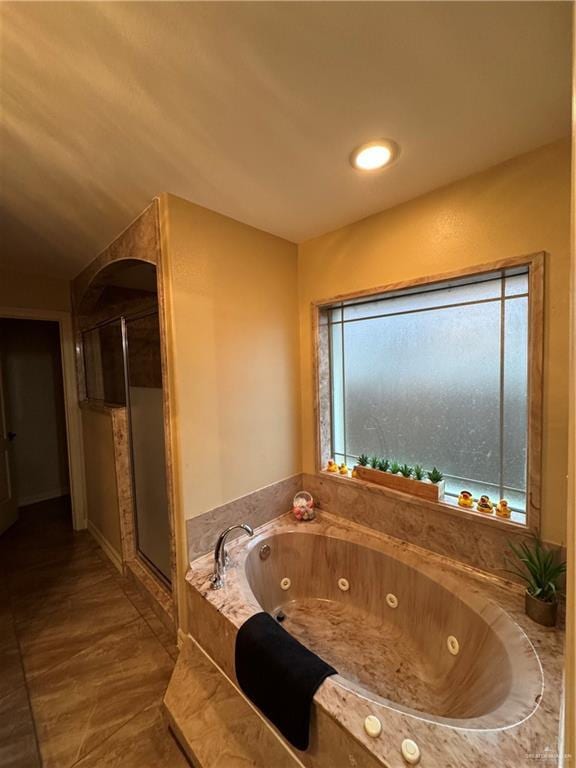 bathroom featuring a stall shower, plenty of natural light, and a whirlpool tub