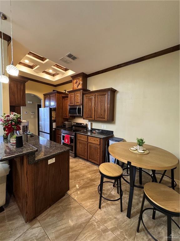 kitchen featuring arched walkways, stainless steel appliances, ornamental molding, and a peninsula