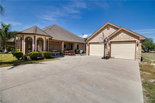 104 El Dora Rd, Alamo, TX 78516 - french country style house featuring concrete driveway, brick siding, and a garage