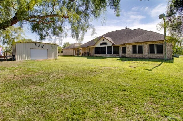 104 El Dora Rd, Alamo, TX 78516 - rear view of property featuring a detached garage, an outdoor structure, and a yard