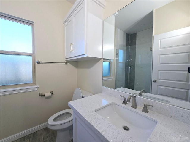 bathroom with wood-type flooring, vanity, toilet, and walk in shower