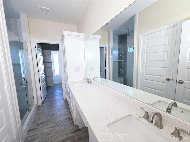 bathroom featuring a shower with door, vanity, and wood-type flooring