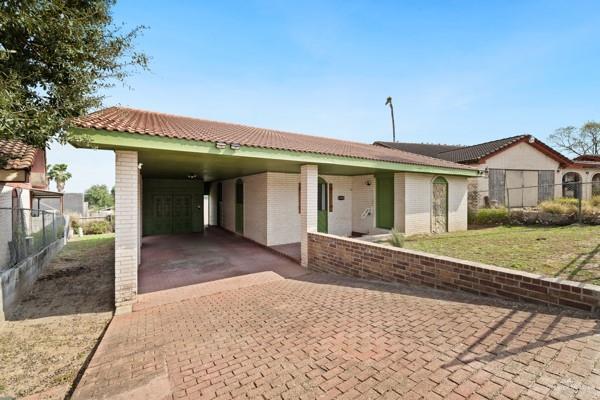 view of front of home with a carport and a front lawn