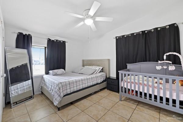 tiled bedroom featuring ceiling fan