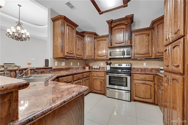 2103 W 30th St, Mission, TX 78574 - kitchen with stainless steel appliances, a sink, backsplash, and light tile patterned flooring