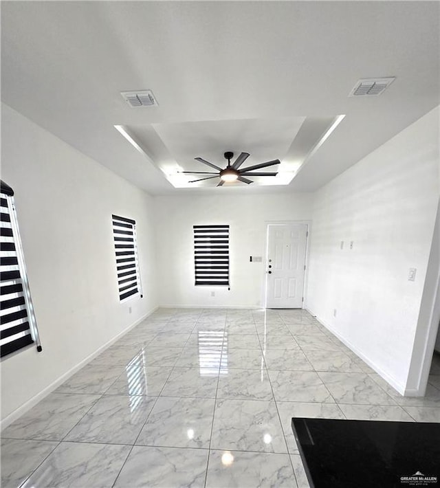 unfurnished room with a tray ceiling and ceiling fan