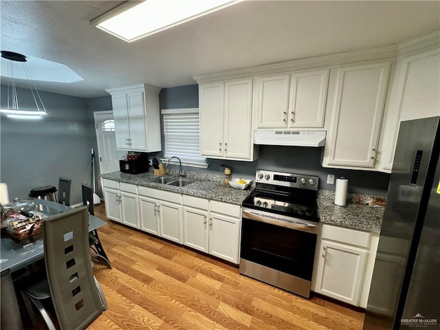 kitchen featuring sink, light hardwood / wood-style flooring, appliances with stainless steel finishes, decorative light fixtures, and white cabinetry