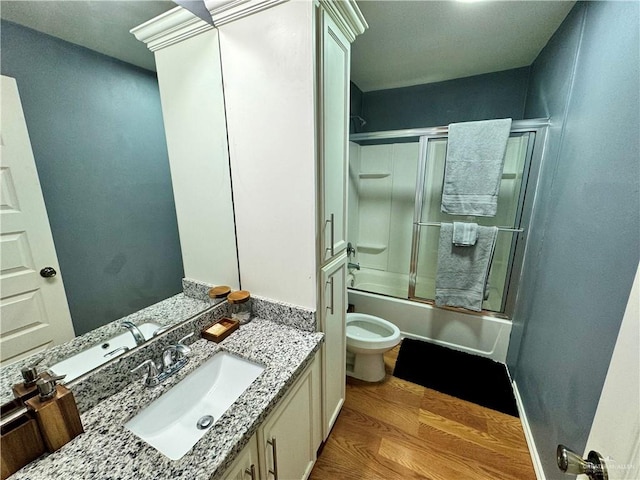 full bathroom featuring vanity, shower / bath combination with glass door, toilet, and wood-type flooring