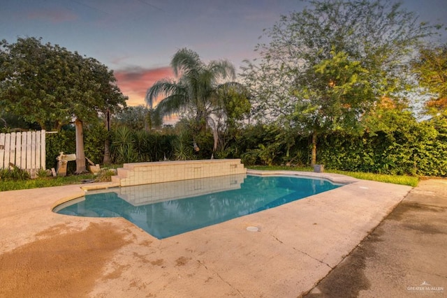 pool at dusk with a patio