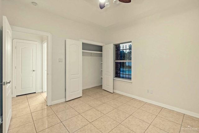 unfurnished bedroom with light tile patterned floors, a closet, and ceiling fan