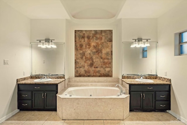 bathroom featuring tile patterned flooring, vanity, and tiled tub