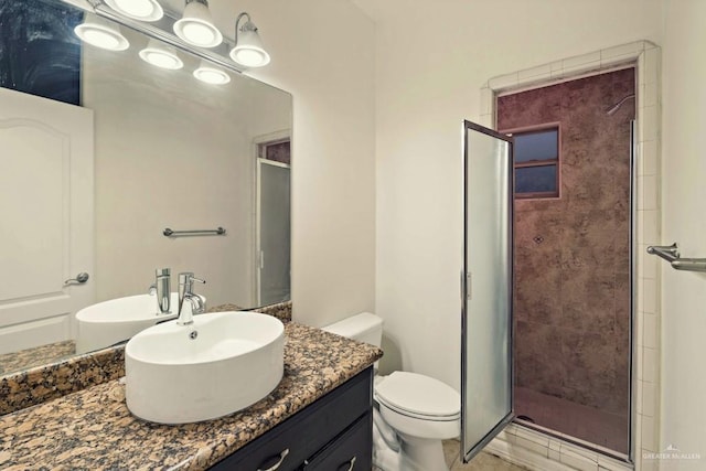 bathroom featuring vanity, toilet, and a shower with door