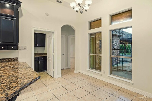 interior space featuring light tile patterned flooring and a notable chandelier