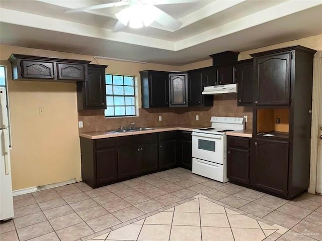 kitchen with sink, decorative backsplash, light tile patterned floors, a raised ceiling, and white appliances